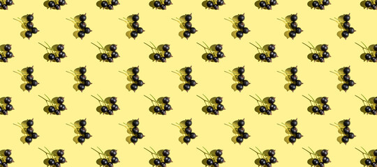 Blackcurrant pattern on a light yellow background. The concept of healthy fresh berries, currants, vegetarianism.