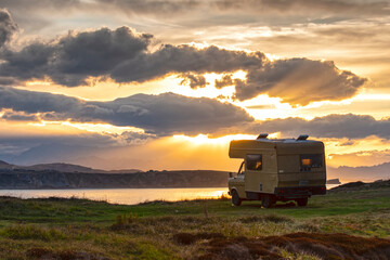 antigua autocaravana en frente del mar al atardecer