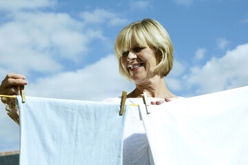 Senior woman hanging laundry on washing line