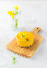 Raw cashew cake with sea buckthorn on a wooden board. Sugar free, gluten, lactose.