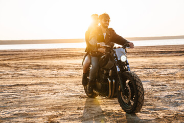 Beautiful young stylish couple enjoying ride on a motorbike