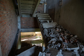 A ruined, crumbling staircase in an abandoned building. A flight of stairs collapsed in the...