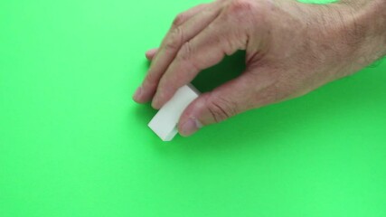 Green screen, hand movement, of adult man with pencil eraser