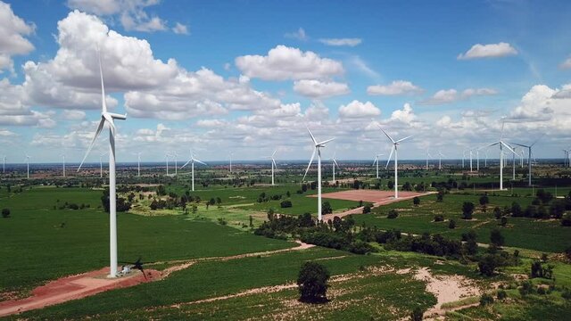 Aerial of Windmills for electric power production with white cloud and blue sky at Huai Bong, Dan Khun Thot district, Nakhon Ratchasima THAILAND. renewable energy and save  environmental concept