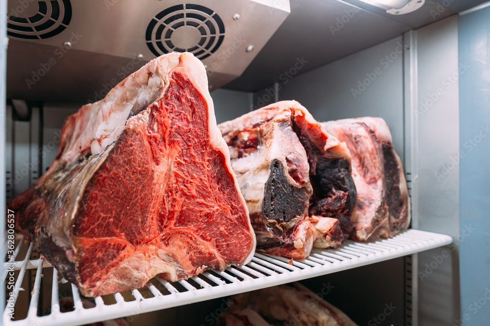 Wall mural Dry-aged Wagyu beef steak with large fillet in the fridge. The preparation process by let the beef break down by natural enzymes, creates a greater concentration of beef flavor, taste and more tender.