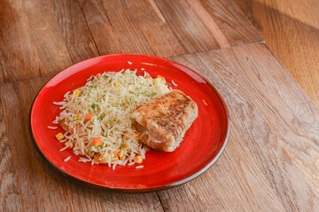 Grilled salmon steak with seasoned rice and vegetables. Restaurant food.