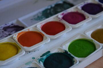 Paint pot aquarel watercolor paints with water and color applied with a paint brush