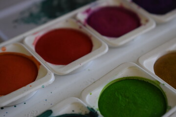 Paint pot aquarel watercolor paints with water and color applied with a paint brush
