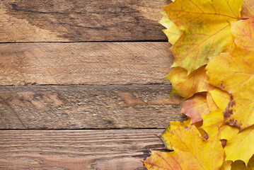 Naklejka na ściany i meble Autumn frame for your idea and text. Autumn fallen dry leaves of yellow, red, orange, laid out on old wooden board of brown color