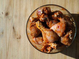 Chicken meat in a marinade in a Cup on the table.