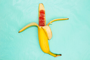 Half-peeled banana, inside which instead of fruit red marmalade in sugar.