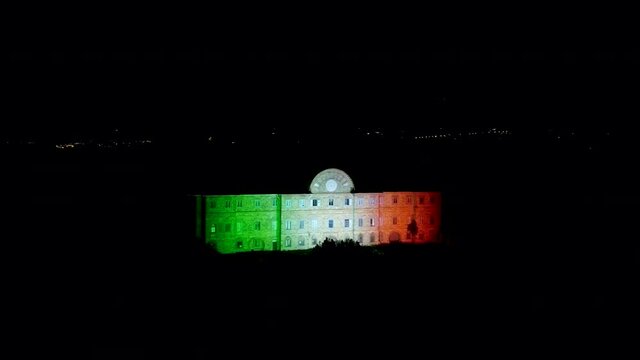 Sammezzano castle at night with italian flag on the main door. Aerial view, early summer.