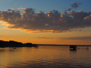 Sunset, summer, beautiful clouds at sunset. Pier on the big Kama river. Ural, Russia, Perm Territory, Elovo.