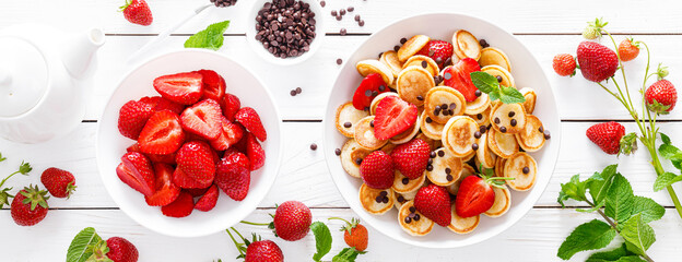 Mini pancakes with fresh strawberry and chocolate drops. Banner