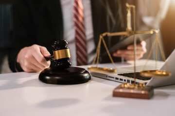 Male lawyer holds a hammer and a tablet in the office.