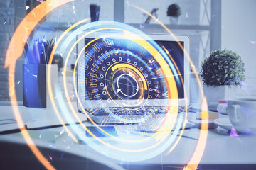 Computer on desktop in office with technology theme hologram. Double exposure. Tech concept.