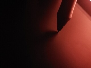 graphic tablet pen on dark reddish background. Graphic design instrument to digitalizing illustration - retouching photos - retouching photos - pen for tablet with touchscreen 