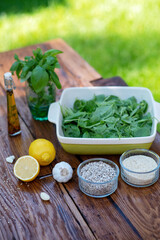 Ingredients for cooking snacks from green spinach sauce with basil, garlic, lemon, sunflower seeds, olive oil and sesame seeds. Organic Health Food Snack or appetizer.