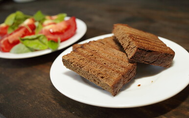  Fresh bread toast. Sliced tomatoes with lettuce on a white plate. Healthy eating concept
