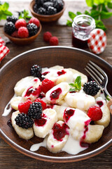Lazy dumplings, vareniki with fresh berries. Boiled cottage cheese gnocchi with sour cream, raspberry and blackberry. Traditional ukrainian cuisine