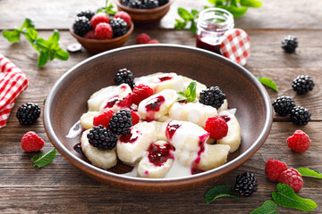 Lazy dumplings, vareniki with fresh berries. Boiled cottage cheese gnocchi with sour cream, raspberry and blackberry. Traditional ukrainian cuisine