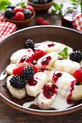 Lazy dumplings, vareniki with fresh berries. Boiled cottage cheese gnocchi with sour cream, raspberry and blackberry. Traditional ukrainian cuisine