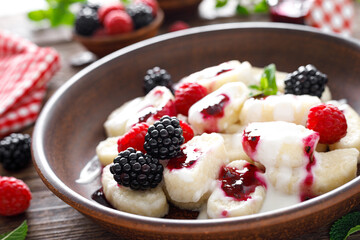 Lazy dumplings, vareniki with fresh berries. Boiled cottage cheese gnocchi with sour cream, raspberry and blackberry. Traditional ukrainian cuisine