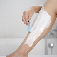 Woman shaving her leg