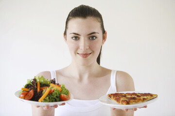 Woman holding pizza and salad