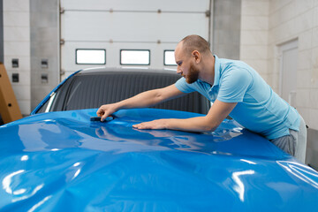Car wrapper installs vinyl foil or film on hood
