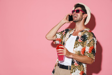 Portrait of laughing man talking on cellphone while drinking soda