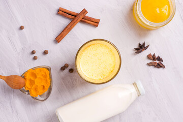 Obraz na płótnie Canvas moon milk with turmeric, yellow Vedic milk with spices, honey, cinnamon, anise and pepper, vegan food