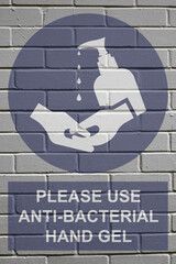 White decayed faded brick wall background with please use anti bacterial hand gel sign to stop the spread of the worldwide pandemic