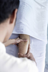 Obraz na płótnie Canvas Massage therapist massaging his customer's leg