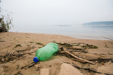 Plastic bottle on the river Bank. Damaging the planet's ecology