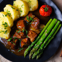 dumplings with beef goulash and green asparagus