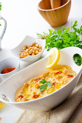 hummus paste with lemon and chilli on white background