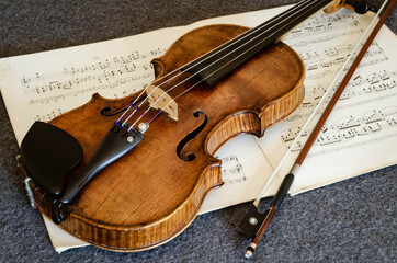 High Angle View Of Violin With Sheet Music On Table
