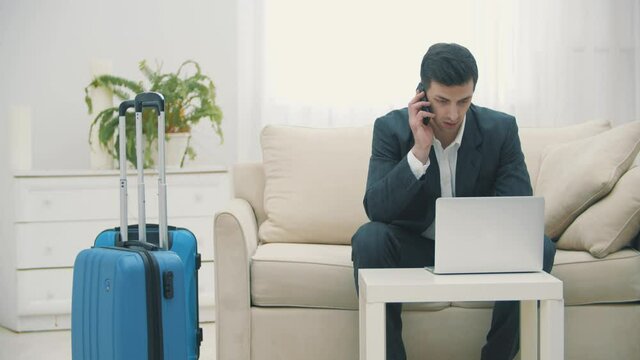 Video of young man using laptop to book airplane tickets or do online check-in at home.