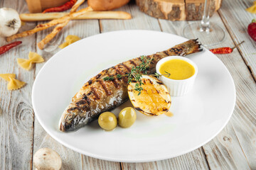 Grilled river trout fish with lemon cream sauce