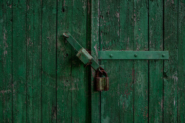 Hinged metal lock on an old wooden door with paint Blumenau