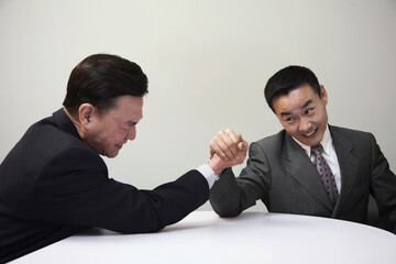 Businessmen arm wrestling