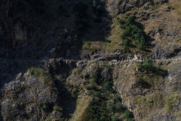 Two cars driving on the road to Manang over Marshyangdi river, Annapurna circuit, Nepal