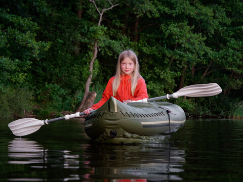 girl is sailing in an inflatable kayak with oars