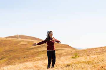 Girl with hat walk with happiness on top of mountain range in autumn.
