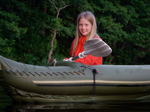girl is sailing in an inflatable kayak with oars