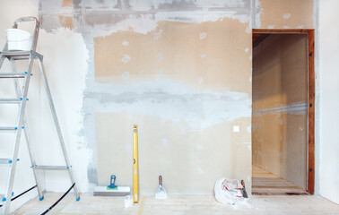 A stepladder with painting tools in a room. Preparing for putty