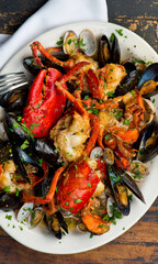 Lobster, mussels, clams and shrimp. Classic Italian restaurant entree favorite. Seafood stew baked in wood fire over and severed with olive oil, lemons and garnished with Italian parsley.