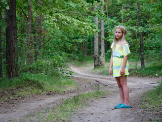 portrait of a blonde girl with blue eyes in green thickets