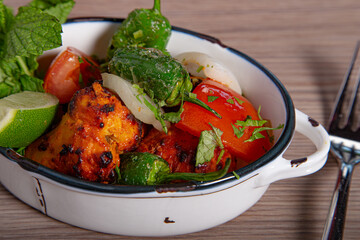 Chicken tikka masala spicy curry meat butter chicken with fresh vegetables.